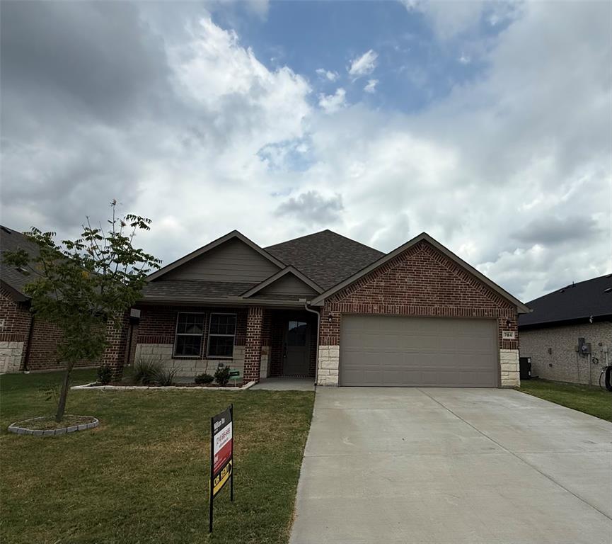 704 Ransom Way Greenville, TX 75402 - Photo 1 of 23 Ranch-style home featuring a garage, brick siding, a front yard, concrete driveway, and a shingled roof