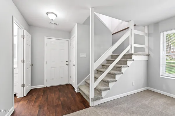 a view of entryway with wooden floor and front door