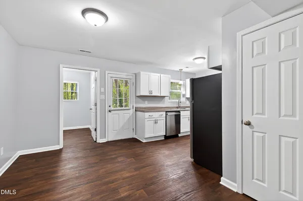 a kitchen with stainless steel appliances a refrigerator and wooden floor