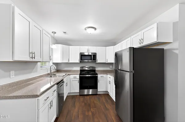 a kitchen with stainless steel appliances a refrigerator stove microwave and cabinets