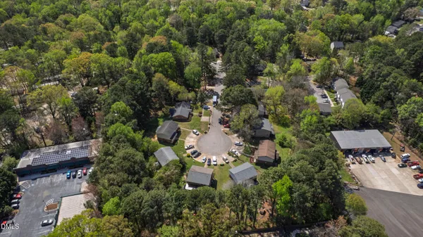 an aerial view of residential house with outdoor space and trees all around