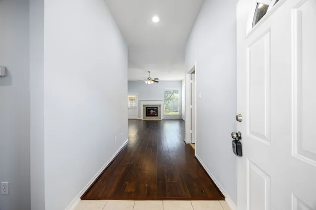a view of a hallway with wooden floor and furniture
