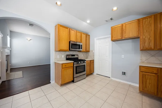 a kitchen with stainless steel appliances a stove a microwave a sink and cabinets