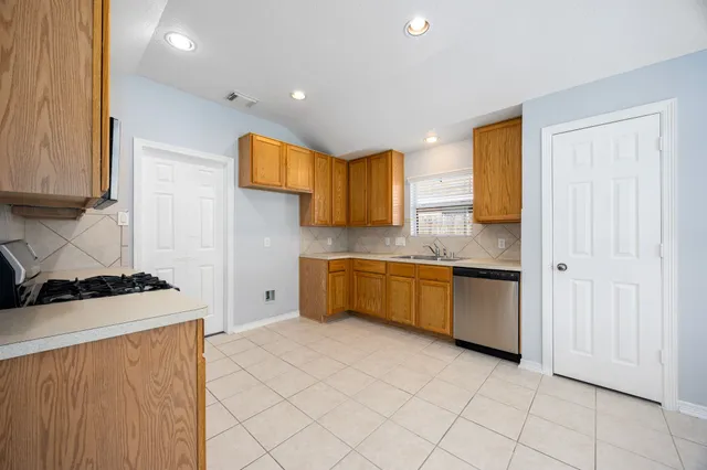 a kitchen with stainless steel appliances granite countertop a stove a sink and a refrigerator