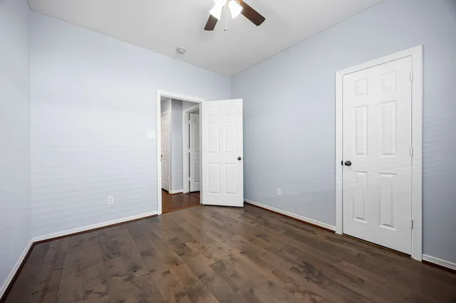 an empty room with ceiling fan and window