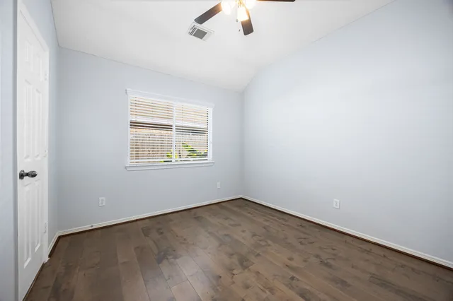 an empty room with a window and a ceiling fan
