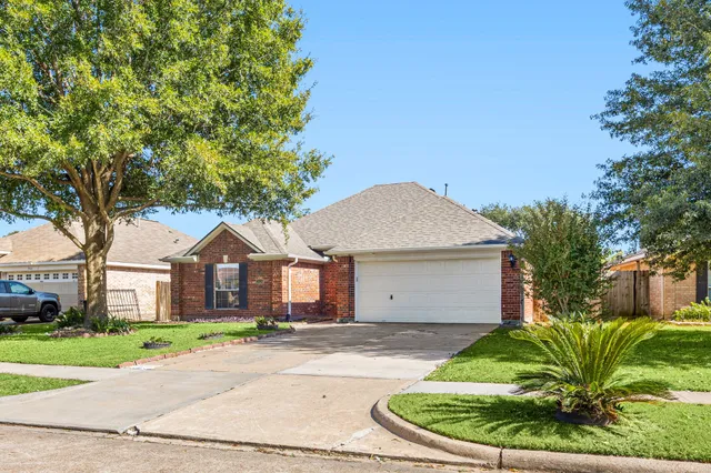 a front view of a house with a garden and trees