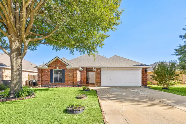 a front view of a house with a garden and trees