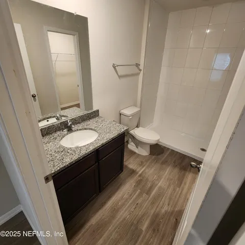 a bathroom with a granite countertop sink toilet and shower