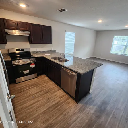 a kitchen with stainless steel appliances granite countertop a stove a sink and a refrigerator