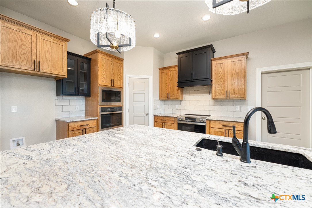 4249 Cold Springs Road Kempner, TX 76539 - Photo 11 of 48 a kitchen with stainless steel appliances kitchen island granite countertop a stove and a sink with granite countertops