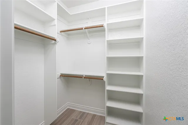 a view of walk in closet with empty racks