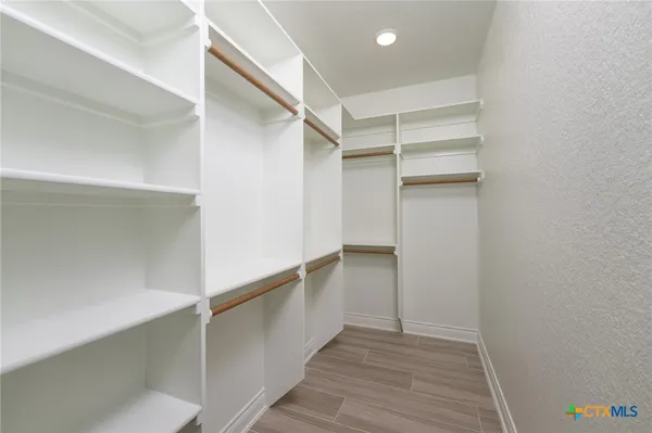 a view of walk in closet with empty racks