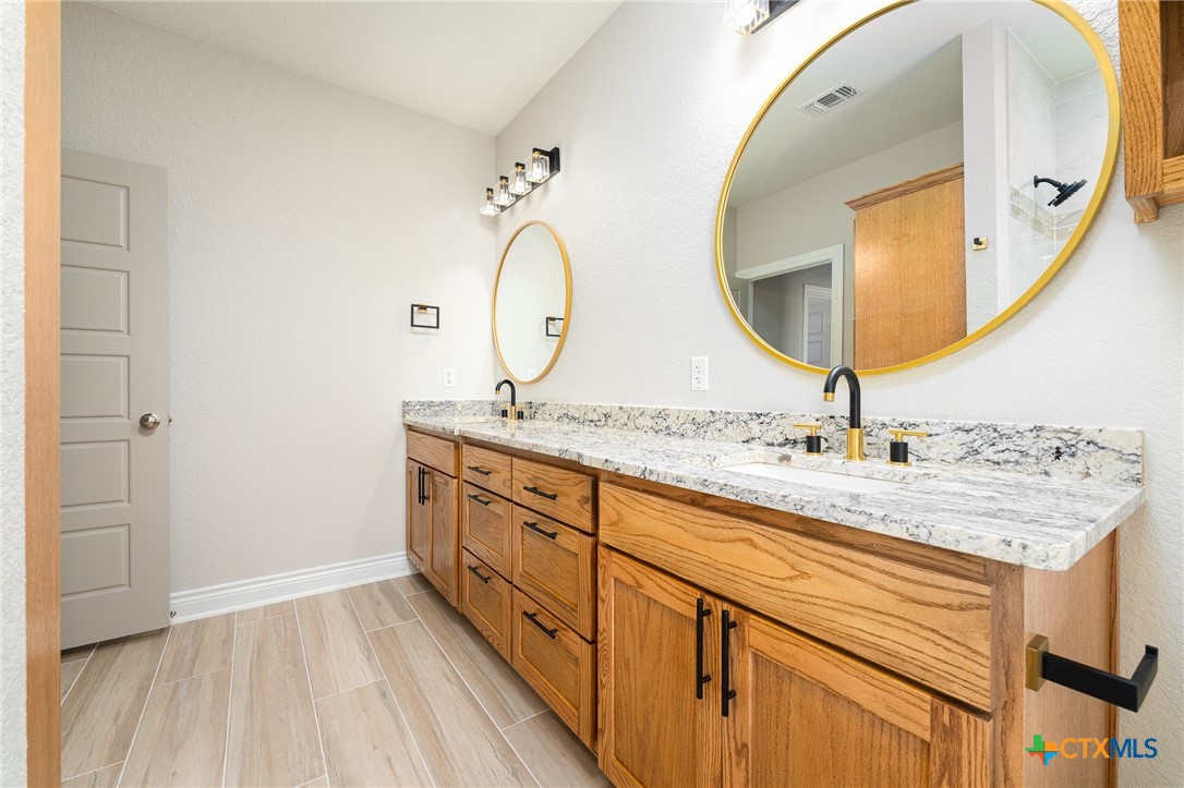 4249 Cold Springs Road Kempner, TX 76539 - Photo 29 of 48 a bathroom with a granite countertop sink and mirror