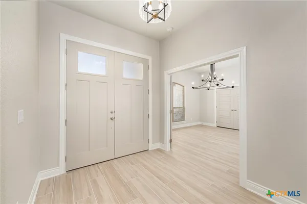 an empty room with wooden floor and ceiling fan