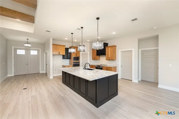 a kitchen with kitchen island sink stove and refrigerator