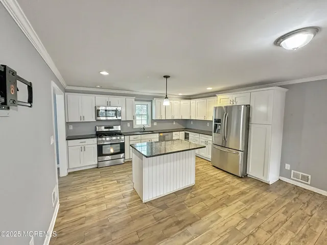 a kitchen with stainless steel appliances a refrigerator sink and cabinets