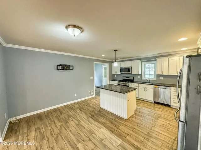 a kitchen with stainless steel appliances granite countertop a stove a sink and a refrigerator