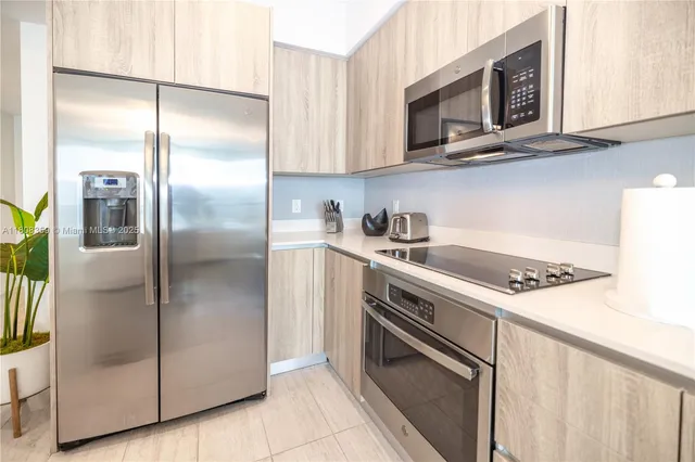 a kitchen with stainless steel appliances a refrigerator sink and microwave