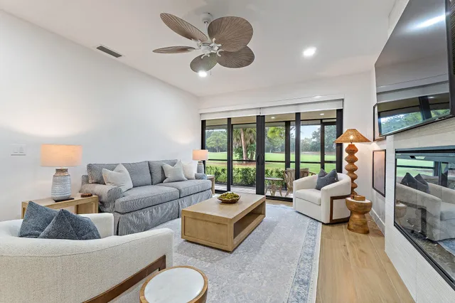 a living room with furniture large window and a flat screen tv