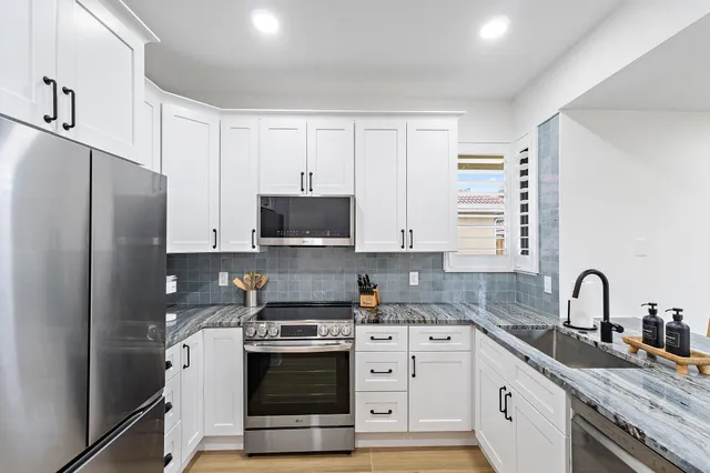 a kitchen with stainless steel appliances granite countertop a sink and a granite counter tops
