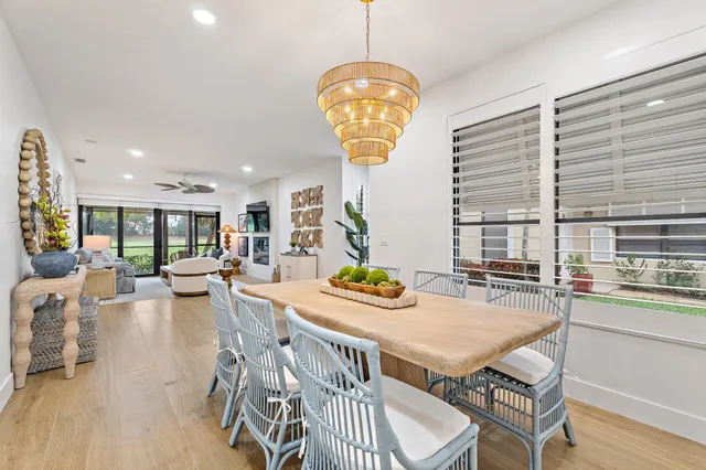 a view of a dining room and livingroom with furniture wooden floor and a chandelier