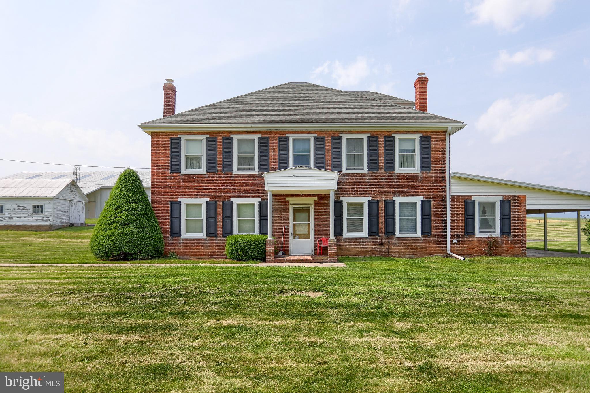 a front view of a house with garden and trees