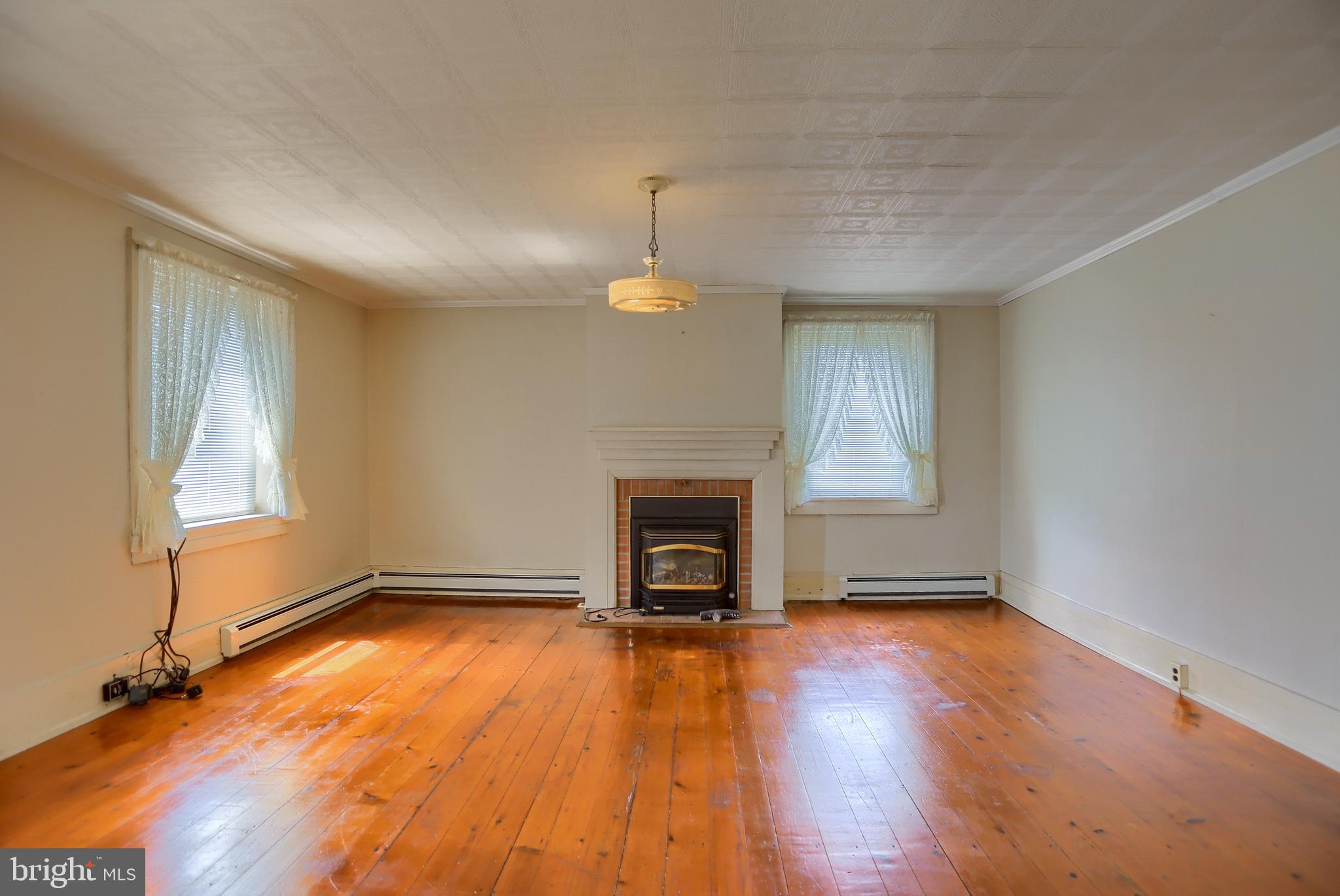 118 Bunker Hill Road Belleville, PA 17004 - Photo 9 of 90 an empty room with a fireplace and windows