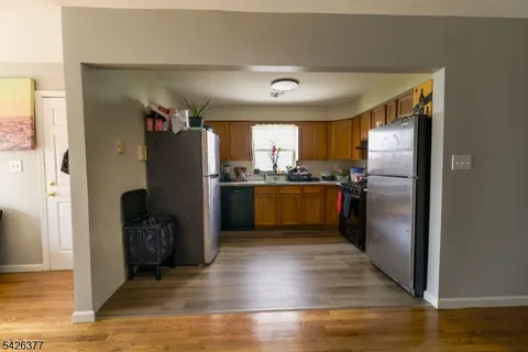 a kitchen with stainless steel appliances wooden floor dining table and chairs