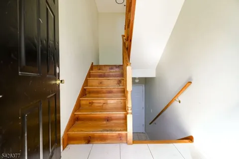 a view of staircase with white walls and black door