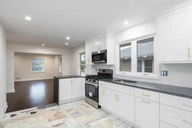 a kitchen with granite countertop a sink and stainless steel appliances