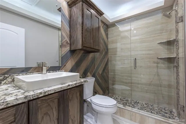 a bathroom with a granite countertop sink toilet and shower