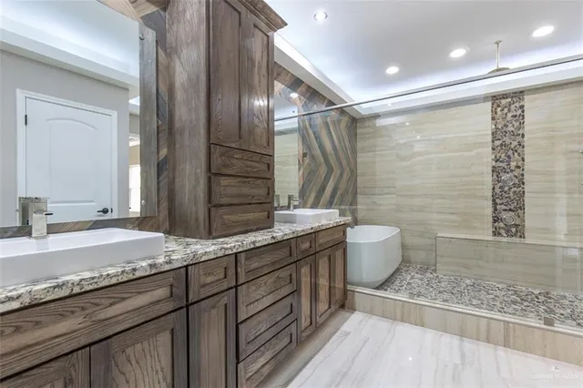 a bathroom with a granite countertop sink a toilet a mirror and shower