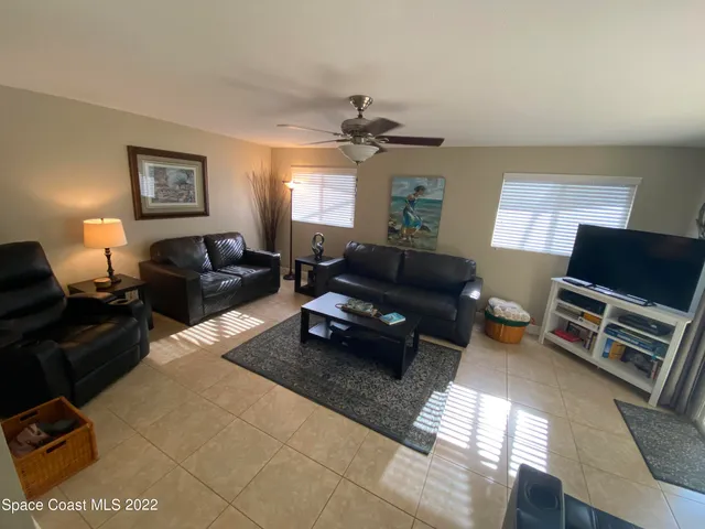 a living room with furniture a window and a flat screen tv