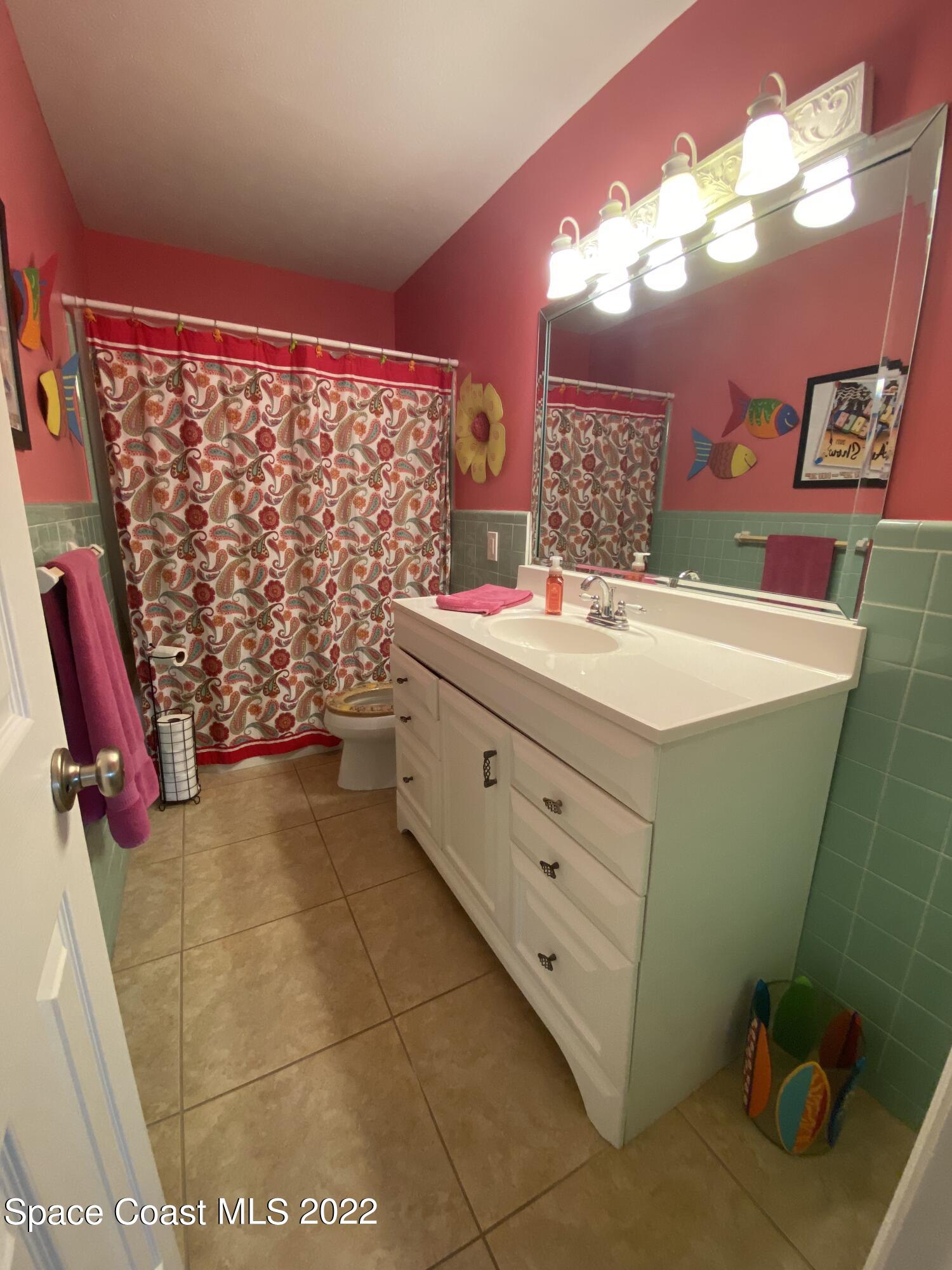 8800 Sea Shell Lane Cape Canaveral, FL 32920 - Photo 6 of 22 a bathroom with a sink mirror vanity and toilet