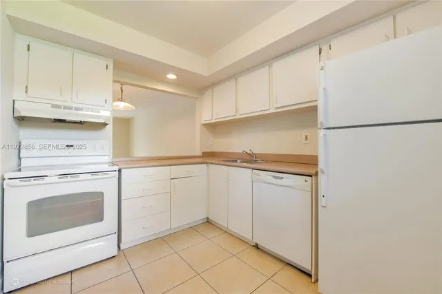 a kitchen with white cabinets and white appliances
