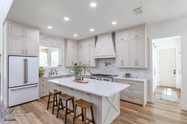 a kitchen with kitchen island a white counter top space a sink appliances and cabinets