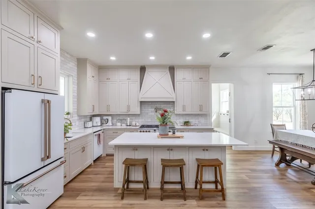 a large kitchen with kitchen island a dining table and chairs