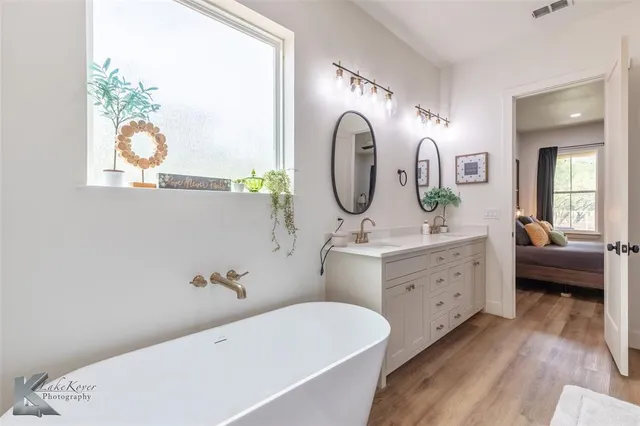 a bathroom with a tub sink and mirror