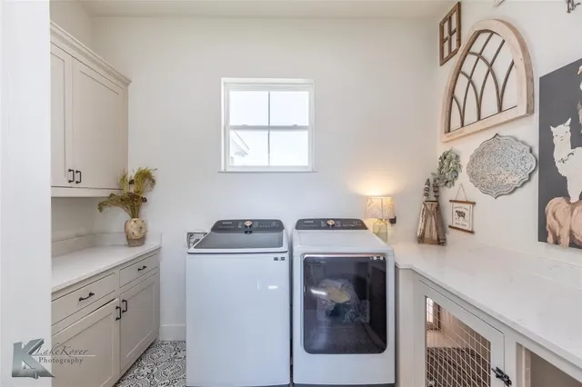 a utility room with cabinets washer and dryer