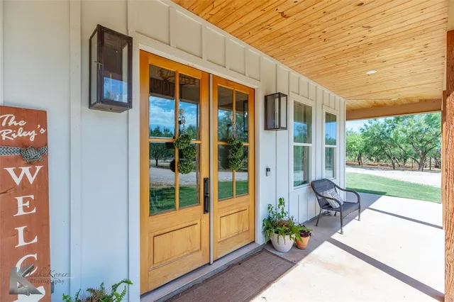 a view of a porch with chairs and potted plants