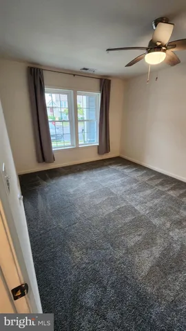 an empty room with closet and a chandelier fan