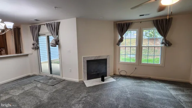 an empty room with windows and a fireplace