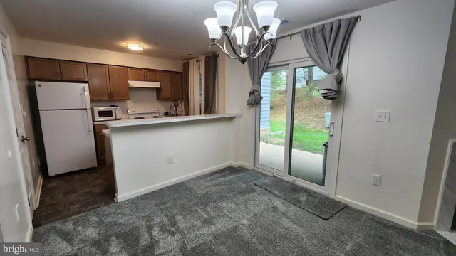 a view of a kitchen with stainless steel appliances granite countertop a refrigerator a sink and a stove