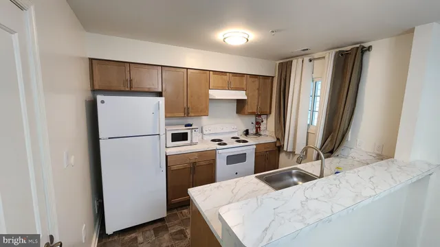a kitchen with a refrigerator a stove and cabinets