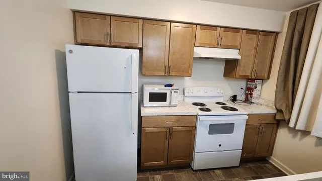 a kitchen with a refrigerator sink stove and cabinets