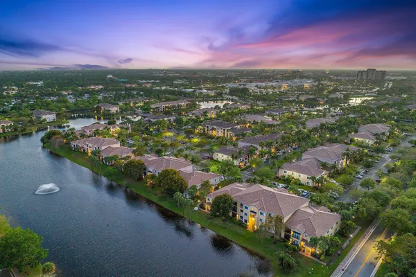 an aerial view of residential houses with outdoor space and trees