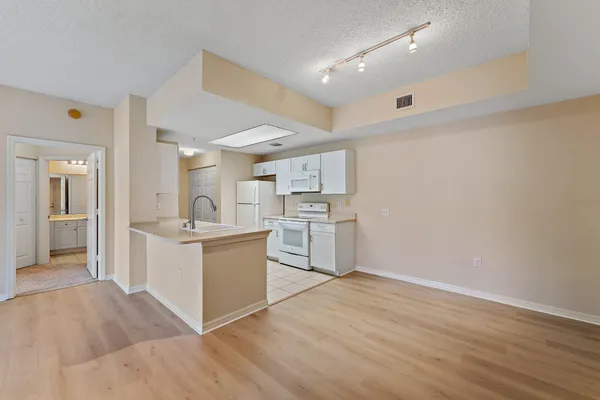a kitchen with sink a microwave and cabinets