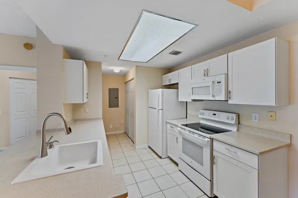 a kitchen with white cabinets and white appliances