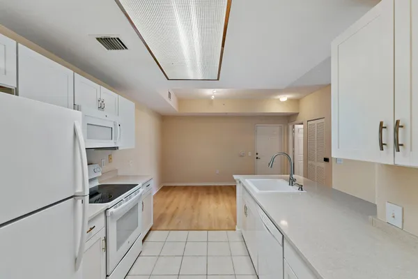 a kitchen with granite countertop a sink stove and refrigerator